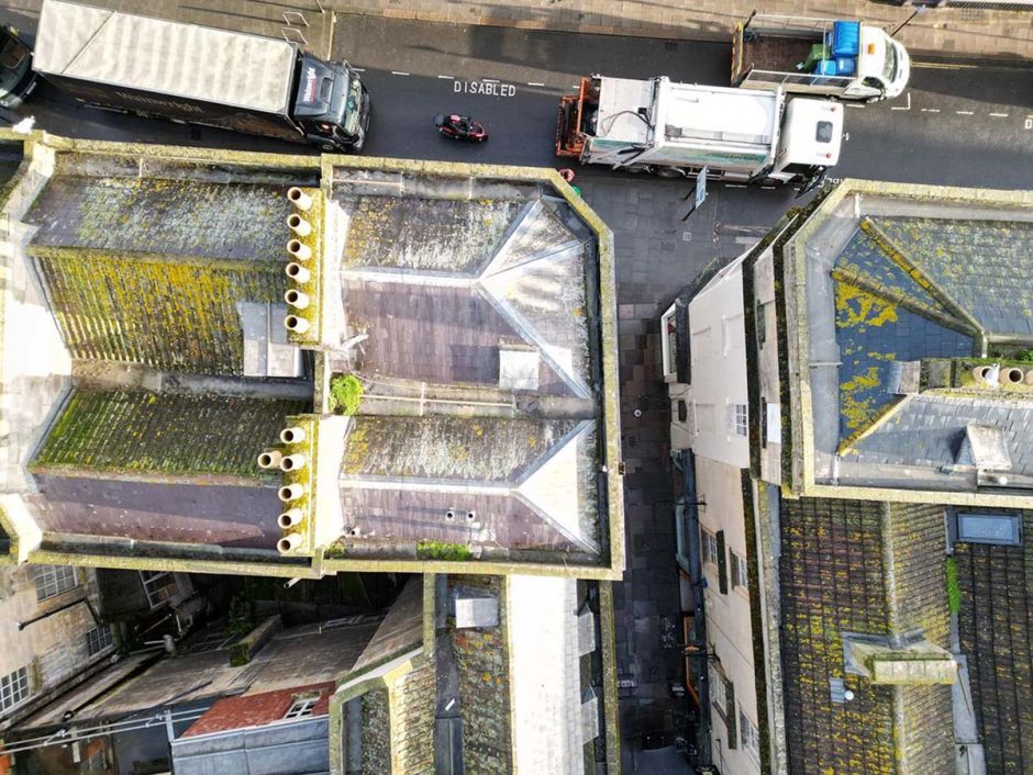 Bird's-eye view of a bustling city street adorned with lush green roofs.